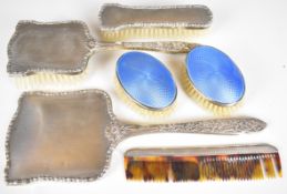 Hallmarked silver mounted dressing table items comprising hand mirror, four bushes incluidng two