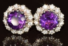 A pair of 9ct gold earrings each set with a round cut amethyst of approximately 1.25ct surrounded by