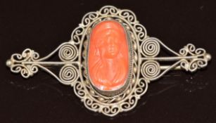 Silver brooch with scrolling decoration set with a coral cameo, 6.4g, 5.2cm