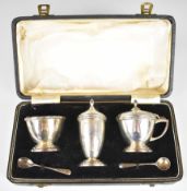 Cased Art Deco hallmarked silver cruet set comprising pepper, salt and mustard, three main pieces