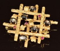 A yellow metal brooch set with rubies and star sapphire cabochons, 12.1g, 4 x 3.5cm