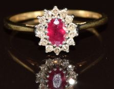 A 9k gold ring set with an oval cut ruby surrounded by diamonds, 2.2g, size R