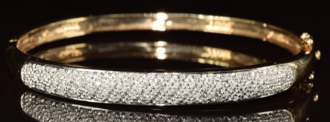 A 9ct gold bangle encrusted with diamonds, 11.6g, 5.8 x 5.1cm