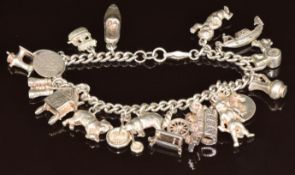 A silver charm bracelet with eighteen silver charms including St Christopher, cat, cherub, etc, 62g