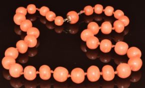 A c1900 necklace made up of graduated coral beads with barrel clasp, largest bead 14 x 11mm,