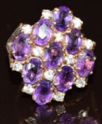 A 9ct gold ring set with nine oval cut amethysts and twelve round cut diamonds, 5.1g, size L