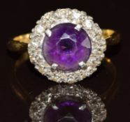 An 18ct gold ring set with a round cut amethyst surrounded by diamonds, 3.4g, size L