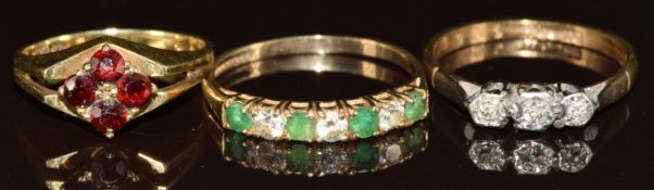 A 14k gold ring set with garnets (2.3g, size I) and two 9ct gold rings one set with emeralds and