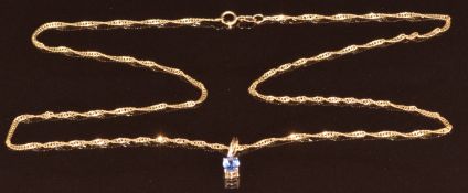 A 9ct gold pendant set with an oval cut tanzanite of approximately 0.4ct and a diamond, on 9ct