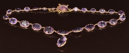 Edwardian 9ct gold necklace set with 24 graduating oval cut amethysts, the largest 9.5ct, the
