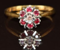 An 18ct gold ring set with a diamond surrounded by rubies in a cluster, 2.7g, size O