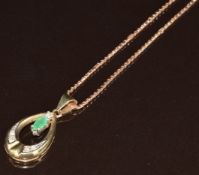 A 9ct gold pendant set with a marquise cut emerald and diamonds (2.6cm) on 9ct gold chain, 5.9g,