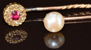 A 9ct gold stick pin set with a pearl and a yellow metal stick pin set with a ruby surrounded by