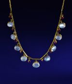 A yellow metal necklace set with eight moonstone cabochons and ten oval cut rubies, each