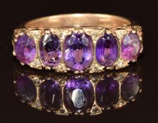 A 9ct gold ring set with five graduated oval cut amethysts and diamonds 4.9g, size O