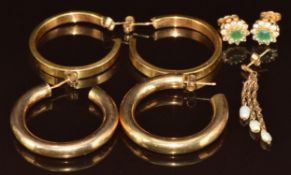 Two pairs of 9ct gold hoop earrings (11.2g), a pair of yellow metal earrings set with emeralds