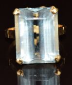 A yellow metal ring set with an emerald cut aquamarine of approximately 14.9ct, 6.9g, size O