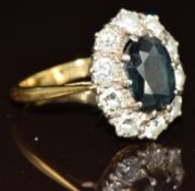 An 18ct gold ring set with an oval cut sapphire of approximately 1.8ct surrounded by ten round cut