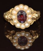 A Victorian 9ct gold ring set with a foiled garnet surrounded by split pearls, 2.9g, size M