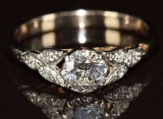 An 18ct gold ring set with a round cut diamond of approximately 0.6ct with diamond encrusted