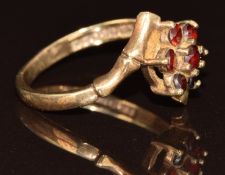 A 9ct gold ring set with a cluster of garnets with bamboo effect shoulders, 2.6g, size N