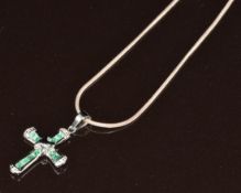 A 9ct white gold cross set with emeralds and diamonds, on silver chain