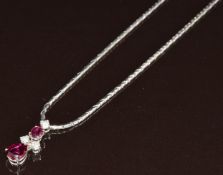 An 18ct white gold necklace set with an oval cut and pear cut ruby of approximately 0.25ct and 0.7ct