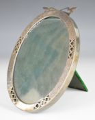 Likely American silver oval photograph frame with pierced and engraved decoration, with green velvet