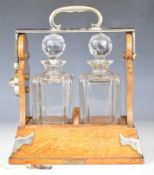 Betjemann's patent oak two bottle 'The Tantalus' with 'Scotch' hallmarked silver bottle ticket,