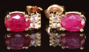 A pair of 9k gold earrings each set with an oval cut ruby of approximately 0.65ct and topaz, 2.1g