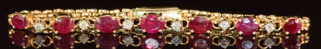 A yellow metal bracelet marked 14k set with seven oval cut rubies ranging from 0.4 to 0.6ct and