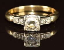 An 18ct gold ring set with a round cut diamond of approximately 0.35ct and two further diamonds to
