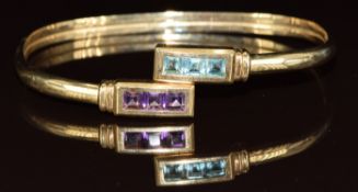 A 9ct gold bangle set with topaz and amethysts, 7.3g