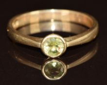 A 9ct gold ring set with a round cut peridot, 2g, size M