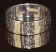 An 18ct white gold ring/ wedding band with textured bark effect finish, 6.2g, size K