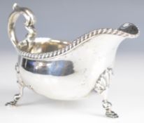 Edward VII hallmarked silver sauce boat with gadrooned edge, scroll handle and raised on three feet,