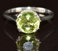 A platinum ring set with a round cut peridot of approximately 1ct, 2.3g, size G