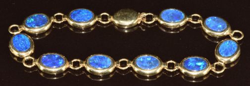 A 14k gold bracelet set with ten oval black opal doublets, 8.4g, 18cm