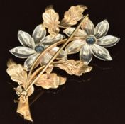 A 9ct bi-coloured gold brooch in the form of two flowers set with two round cut zircons, 10.2g, 5.