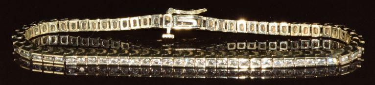 A 14ct gold tennis bracelet set with seventy round cut diamonds, the total diamond weight