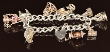 A silver charm bracelet with nine silver charms including car, bell, shoes, poodle, etc, 68g