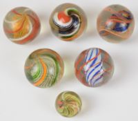 Six vintage latticino core glass marbles, largest diameter 4cm.