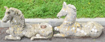 Pair of reconstituted stone statues of recumbent horses, approximately 85cm in length and 60cm high