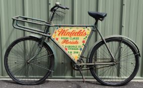 Vintage tradesman's bicycle with Stroud interest florist's painted advertising panel in the frame