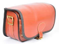Brown leather shotgun cartridge loader's bag with shoulder strap, unused in original box.