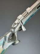 Remington Model 700 .223 bolt-action rifle with blue laminate show wood stock, thumb-hole grip,