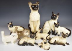 Ten Beswick cat figures including fireside Siamese, tallest 36cm