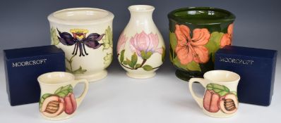 Two Moorcroft jardinières, vase and two boxed mugs including Magnolia and Hibiscus patterns, tallest