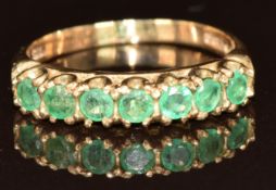 A 9ct gold ring set with seven emeralds, each approximately 0.1ct, 2.5g, size P