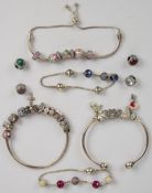 Two Pandora bangles with eighteen charms and three Pandora bracelets with twenty one beads/